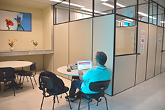 Imagem dentro da Biblioteca JFPE que tem mesas e cadeiras onde se faz pesquisas e estudos